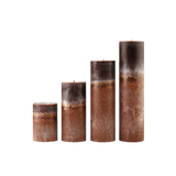Set of four brown cylindrical candles with textured surface on a white background