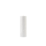 White pillar candle on a white background