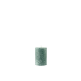 Green textured candle on a white background