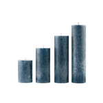 Set of four textured blue candles of different sizes on a white background