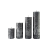 Set of five textured gray candles of different sizes on a white background