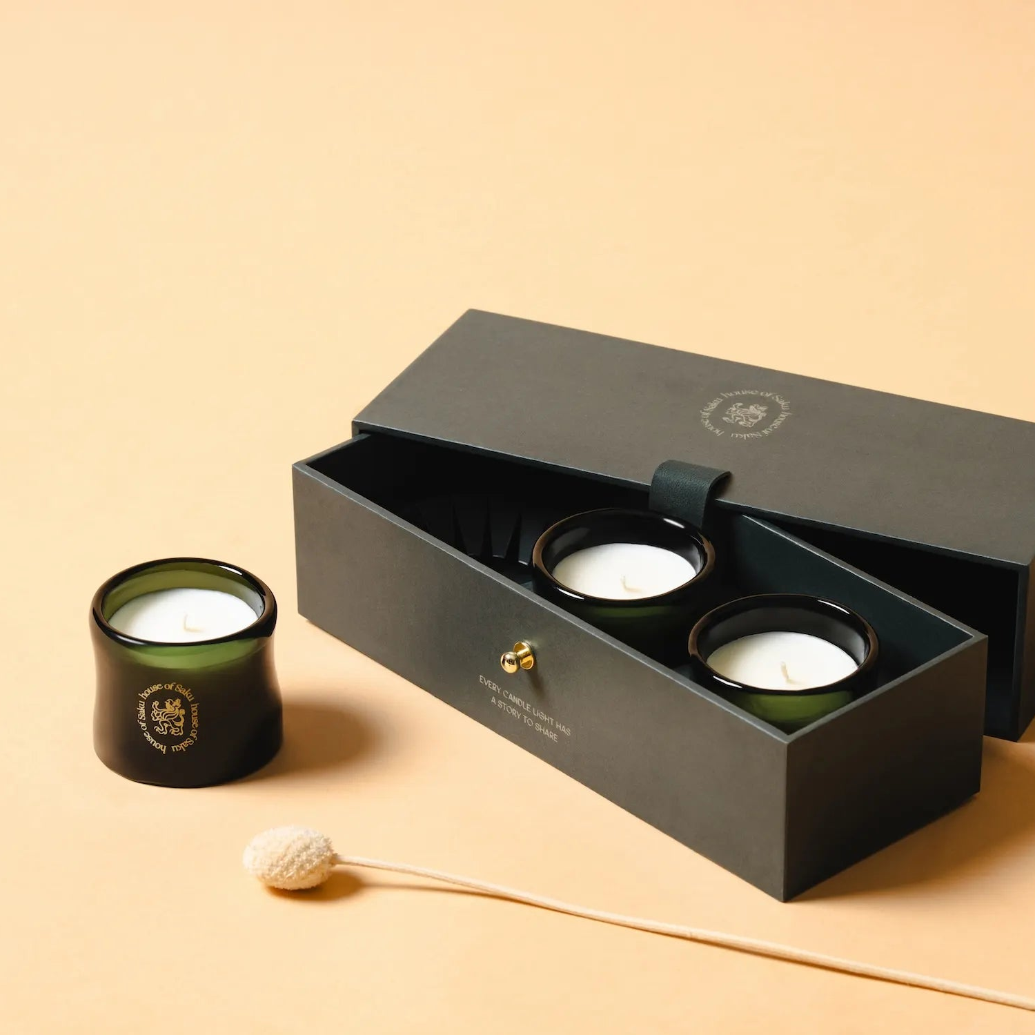 Set of candles in a black box on a beige background